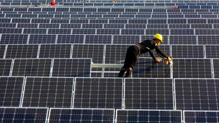 Radnik radi na solarnim panelima u Kini