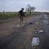Ukrainian serviceman walks on a road past remains of a Russian kamikaze drone outside the frontline city of Kostiantynivka