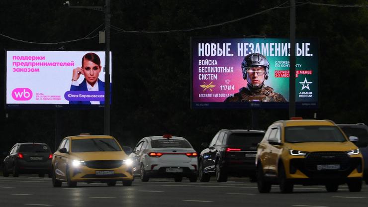 Cars drive past a screen advertising online retailer Wildberries in Moscow