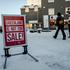 People walk past a sign placed on a street in Nuuk