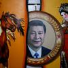 A portrait of Chinese President Xi Jinping seen next to traditional paintings in Hohhot