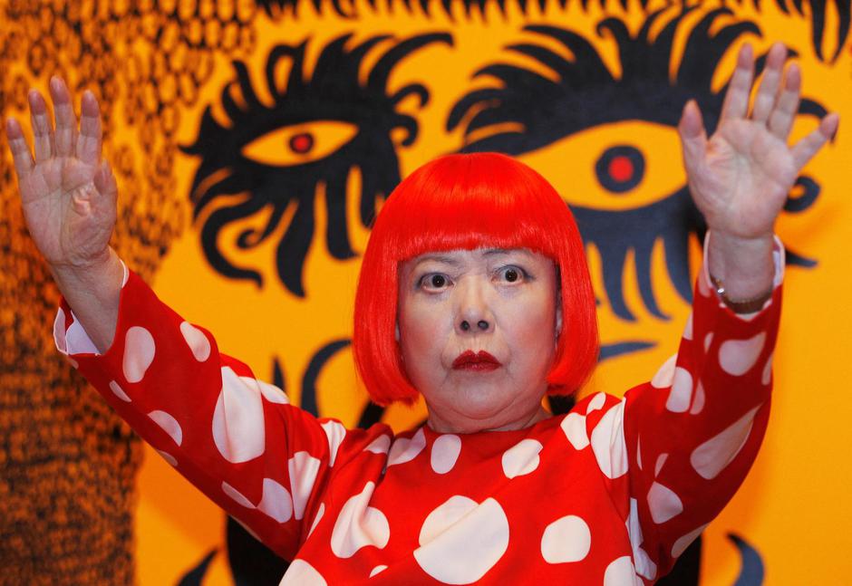 FILE PHOTO: Artist Yayoi Kusama poses for a photograph with a detail from her artwork "Love arrives at the Earth Carrying with it a Tale of the Cosmos" at the Tate Modern gallery in London | Author: Luke MacGregor/REUTERS