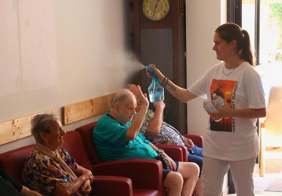 Residents at the house for elderly persons are refreshed by a staff member with a mist moisturiser, as a heat wave hits Europe, in Chatelet | Author: YVES HERMAN/REUTERS