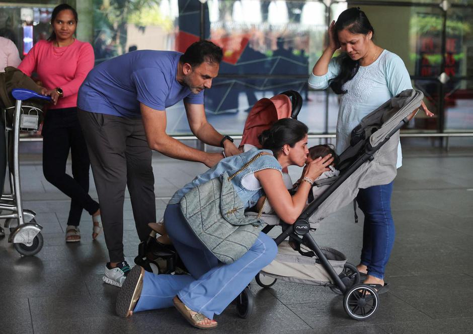 Nirav Modi, who was stranded in Dubai amid the U.S.-Israel conflict with Iran, along with his twins watches as his wife kisses her child at the Chhatrapati Shivaji Maharaj International Airport in Mumbai | Author: FRANCIS MASCARENHAS/REUTERS