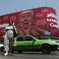 People walk near a billboard depicting U.S. President Donald Trump on a building in Tehran