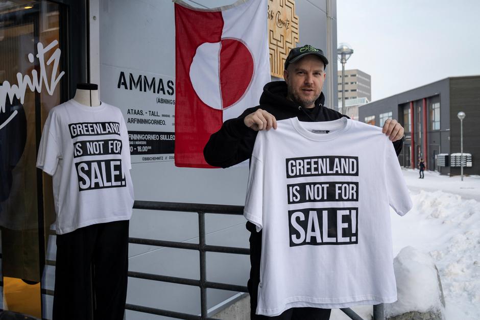 A shop owner David Rogilds holds a shirt that he sells in Nuuk | Author: Marko Djurica