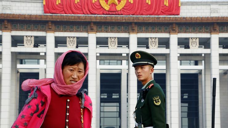 Kineski policajac nadgleda ljude na trgu Tiananmen