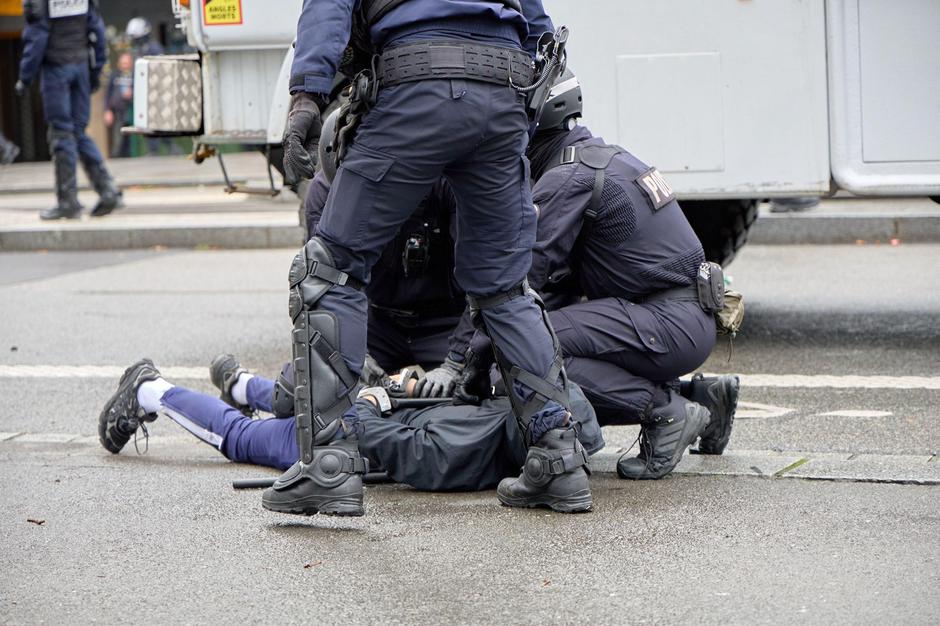 RENNES, FRANCE - 13 OCTOBER 2026: Riot police detain a man lying face down on the road beside a CRS water cannon truck during a street demonstration | Author: Profimedia