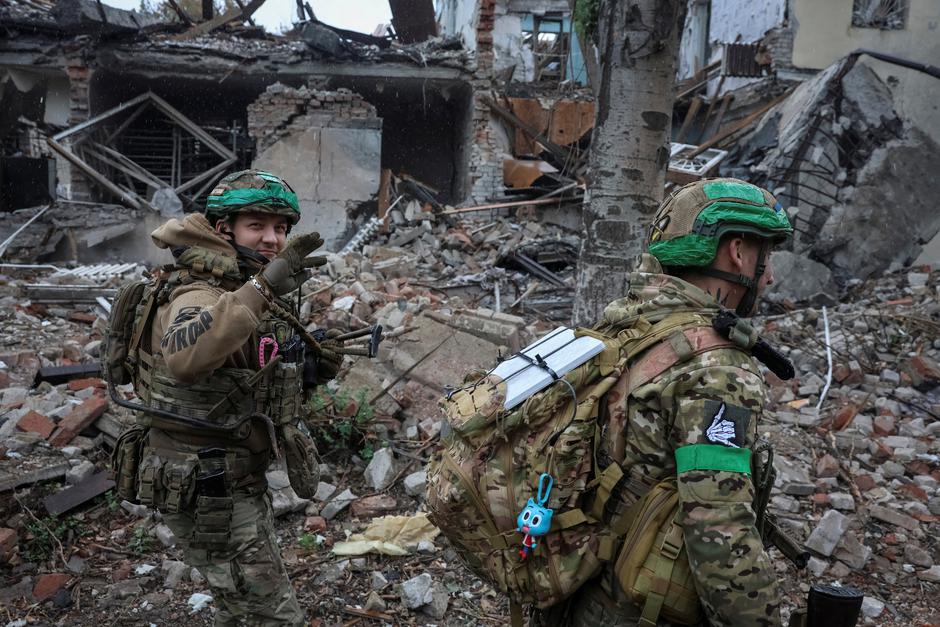 Ukrainian servicemen walk past a damaged apartment building  in the frontline town of Druzhkivka | Author: Anatolii Stepanov
