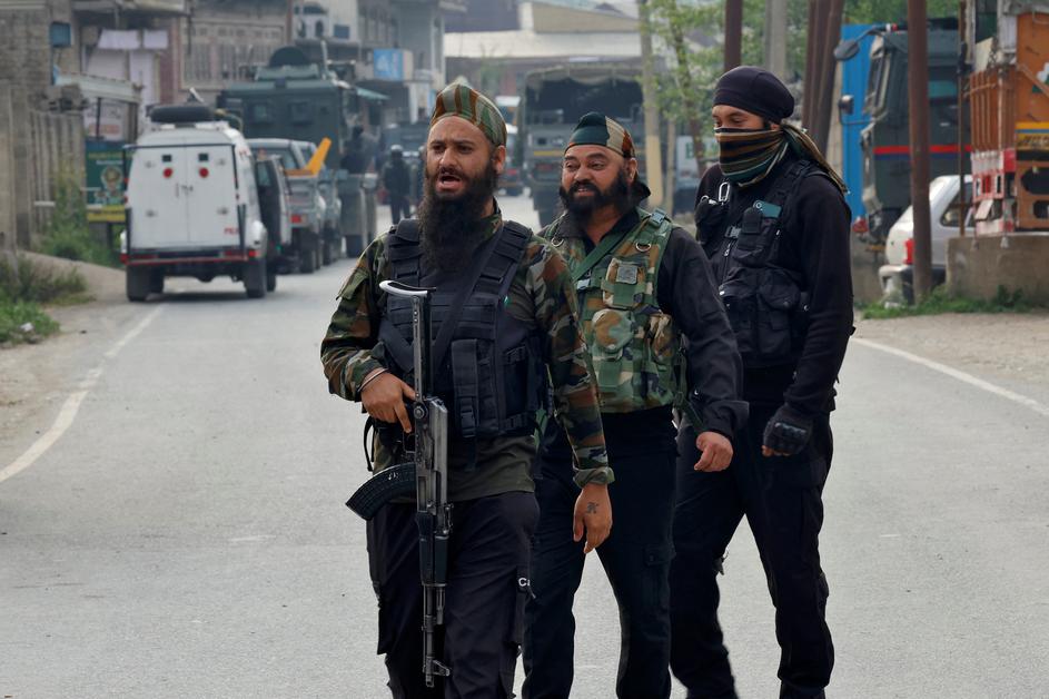 Indian security force personnel stand guard near the site of a fighter jet crash in Wuyan