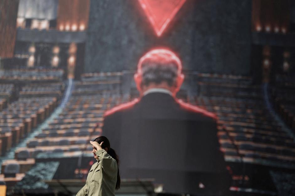 A woman walks past a billboard depicting Israeli Prime Minister Benjamin Netanyahu in the empty hall of the United Nations, on a building in Tehran | Author: Majid Asgaripour