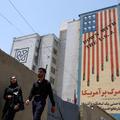 People walk near an anti-U.S. mural in Tehran