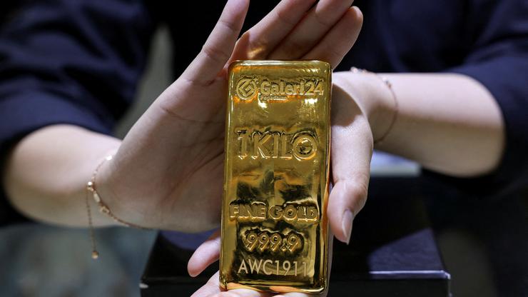 FILE PHOTO: A staff member shows a one kilogram gold bar at the Galeri 24 gold and jewellery shop in Jakarta