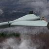 Russian military combat drone Shaheed flies over a forest, smoke from military action in Ukraine.