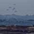An aircraft drops humanitarian aid packages over the Gaza Strip, as seen from Israel