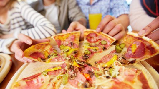 Puno ljudi jede jumbo pizzu