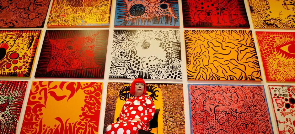 FILE PHOTO: Artist Yayoi Kusama poses for a photograph with her artwork "Love arrives at the Earth Carrying with it a Tale of the Cosmos" at the Tate Modern gallery in London | Author: Luke MacGregor/REUTERS