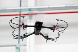 Augsburg, Bavaria, Germany - September 30, 2025: A DJI Mavic 3 drone hovers in flight with LED light on and protective f