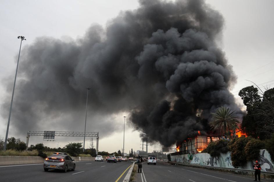 Fire ignited at the impact site following an Iranian missile strike, amid the U.S.-Israeli conflict with Iran, in central Israel