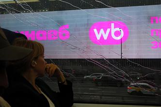 A woman rides a train past a screen advertising the Wildberries online retailer in Moscow