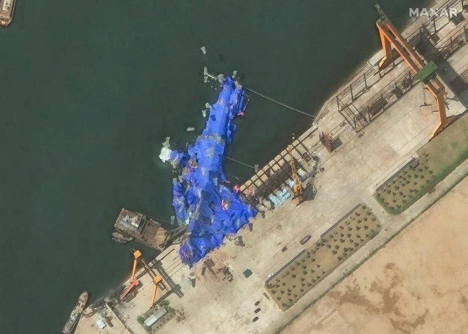 A satellite image shows a North Korean warship covered with a blue tarp after an accident that occurred during its launch at the shipyard in Chongjin | Author: MAXAR TECHNOLOGIES/REUTERS