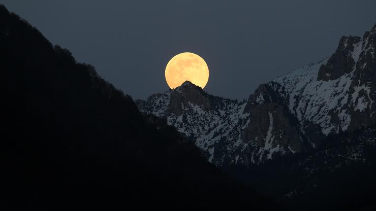 Pun mjesec iznad bijelih alpskih vrhova