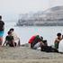 Migrants from Morocco sit on the Spanish side of the border, in Ceuta