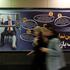 People walk past a sign with a picture depicting injured U.S. President Donald Trump, in Tehran