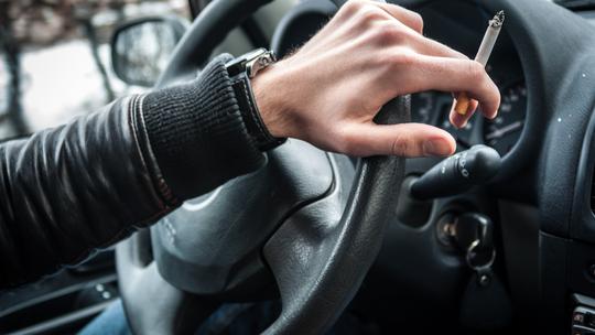Muškarac puši za volanom automobila