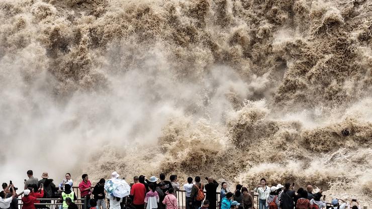 YAN AN, CHINA - SEPTEMBER 20: Tourists visit the Hukou Waterfall on the Yellow River as water volume significantly incre
