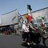 People ride past a mural depicting the late leader of the Islamic Revolution, Ayatollah Ruhollah Khomeini, and the late Iran's Supreme Leader Ayatollah Ali Khamenei, on a street in Tehran