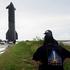Passersby look on as a SpaceX Starship spacecraft rolls out toward its launch pad before its 10th test flight