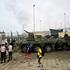 People gather near armoured vehicles at the Spanish border, in Ceuta