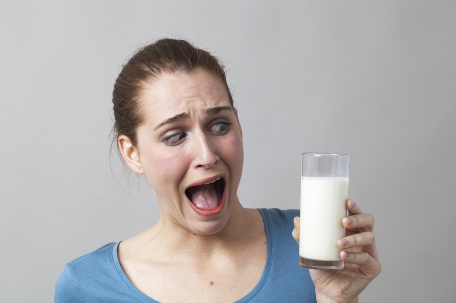 Žena koja sa strahom gleda u čašu mlijeka | Author: Thinkstock