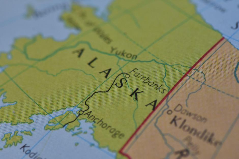 Detailed map of Alaska featuring the Aleutian Islands, Bering Sea, and Anchorage on a printed atlas with selective focus on the northern territory. | Author: 