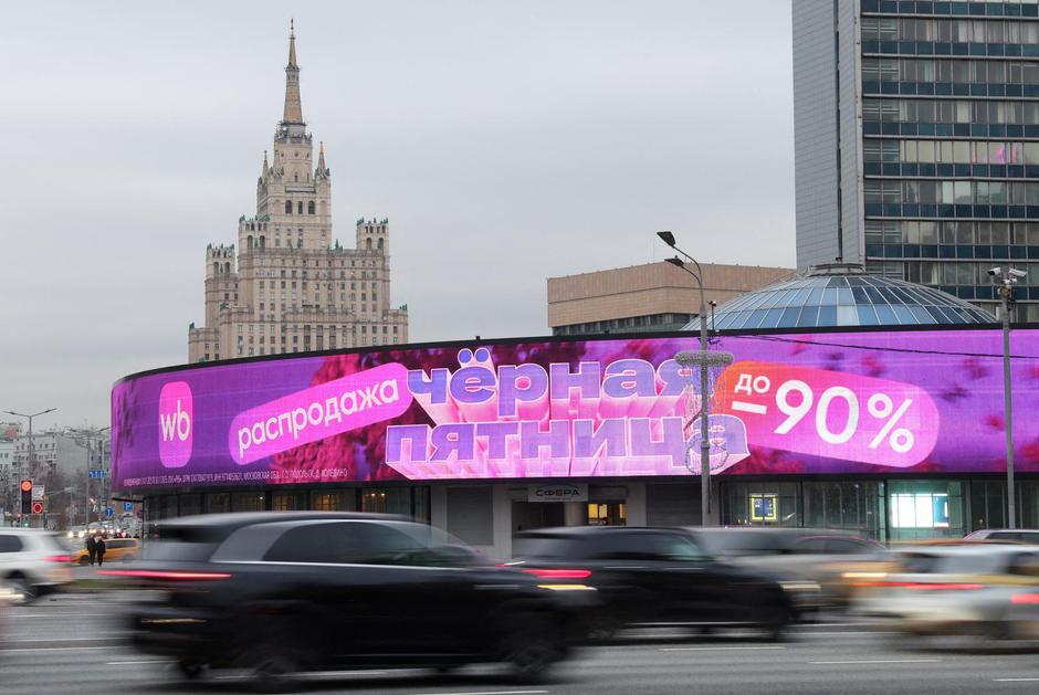 FILE PHOTO: Cars drive past a screen advertising a Black Friday sale at the Wildberries online retailer in Moscow | Author: ANASTASIA BARASHKOVA/REUTERS