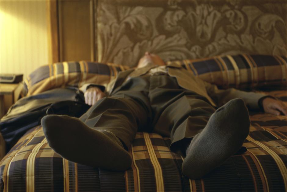 Muškarac koji se odmara na krevetu nakon napornog dana | Author: Thinkstock