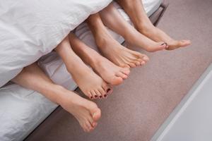 Noge troje ljudi u krevetu