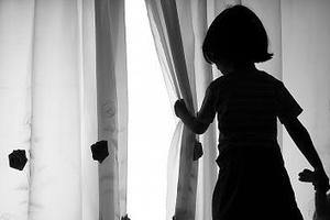Djevojčica gleda kroz zavjesu