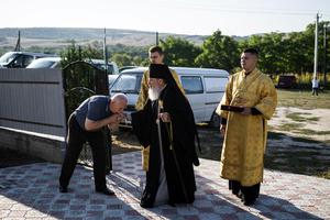 A man kisses Archbishop Marchel's hand as he arrives for his Mass at a church in Slobozia-Magura