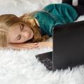 Djevojka spava ispred laptopa
