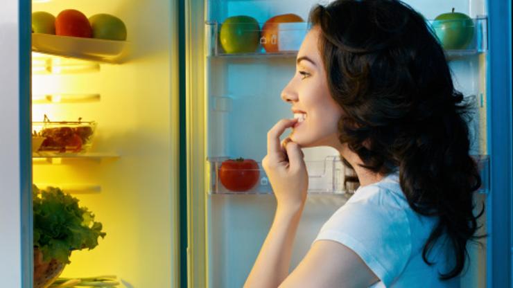 Žena proučava hranu u hladnjaku