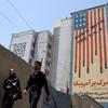 People walk near an anti-U.S. mural in Tehran
