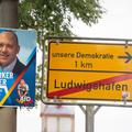 (Fotomontage) Plakat des ausgeschlossenen Ludwigshafener Bürgermeisterkandidaten Joachim Paul (AfD), daneben ein Ortsaus