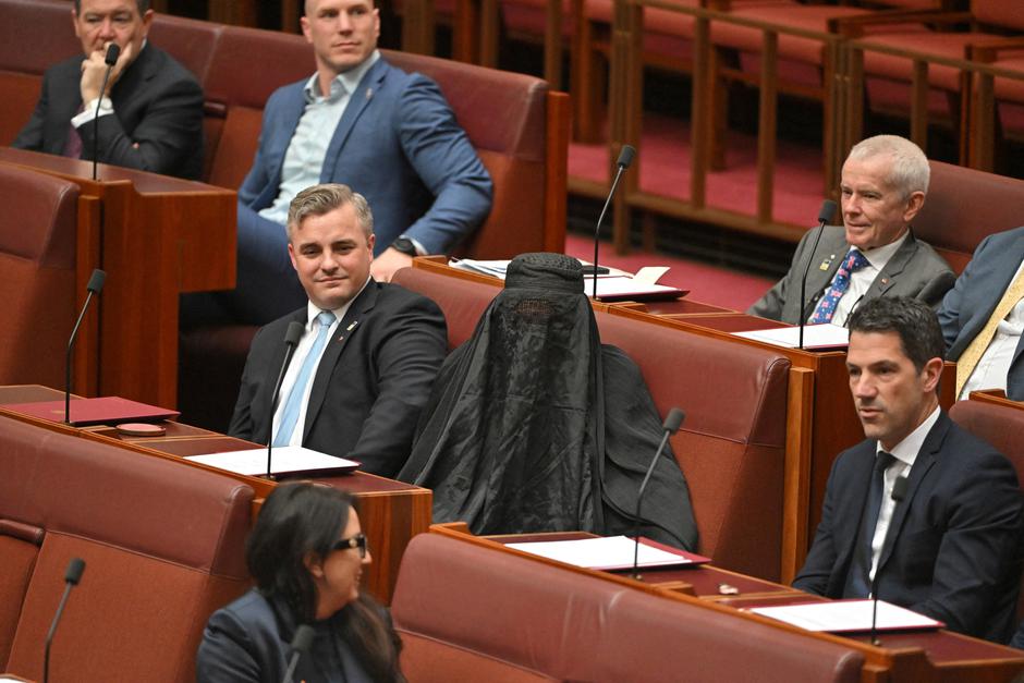 Senators react as One Nation leader Hanson wears a burqa in the Senate chamber at Parliament House in Canberra | Author: MICK TSIKAS