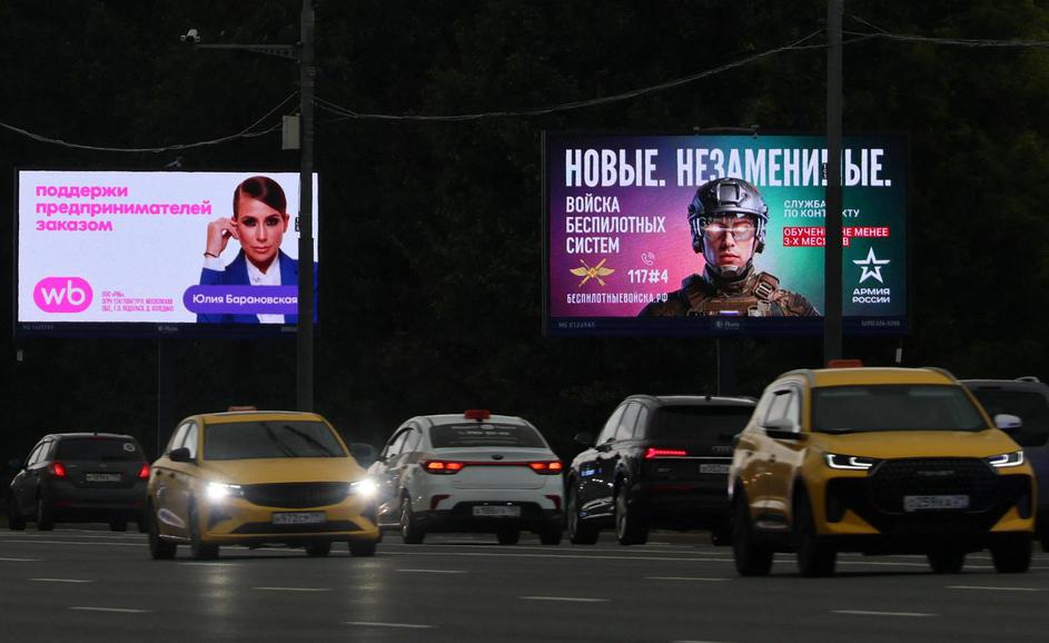 Cars drive past a screen advertising online retailer Wildberries in Moscow