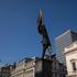 Banksy Confirms latest artwork In Waterloo Place, Westminster, England, United Kingdom Tourists gather underneath the satirical statue, which depicts a man marching off a precipice while blinded by a massive flag, which has appeared outside the Athenaeum