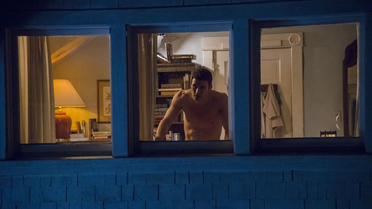 Filmska scena u kojoj muškarac gleda kroz prozor kuće