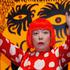 FILE PHOTO: Artist Yayoi Kusama poses for a photograph with a detail from her artwork "Love arrives at the Earth Carrying with it a Tale of the Cosmos" at the Tate Modern gallery in London