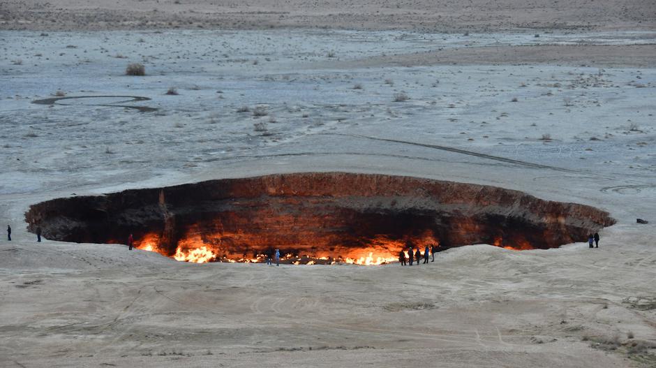 Pictured:  Vistors along the edge of the gas craterA photographer was confronted with an amazing inferno as he visited a gas crater which locals call 'The Gates of Hell' - because it has been burning for 46 years. | Author: Profimedia